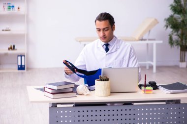 Klinikte çalışan genç erkek travmatolog.