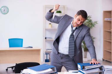 Bıçak tutan genç bir işçi aşırı çalışmaktan kızgın.