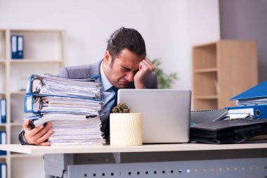 Genç bir erkek işçi aşırı işten memnun değil.