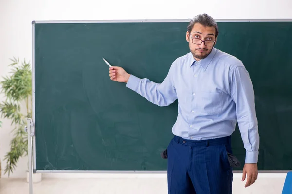 Jovem professor do sexo masculino mal pago em sala de aula — Fotografia de Stock