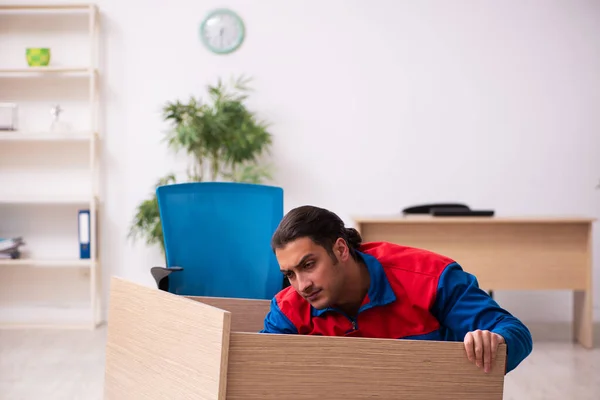 Young male contractor repairing furniture in the office — Stock Photo, Image