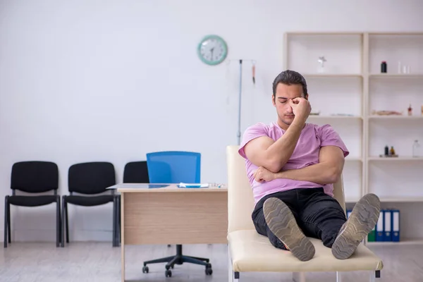 Paciente varón joven que espera al médico en la clínica — Foto de Stock