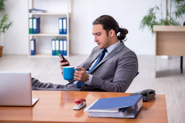 在办公室喝咖啡的年轻男性员工 — 图库照片