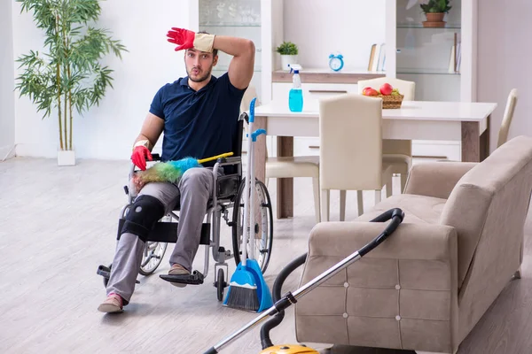 若い足が負傷した請負業者車椅子で家を掃除 — ストック写真