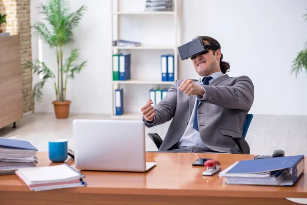 Mladý muž zaměstnanec nosí virtuální brýle v kanceláři — Stock fotografie