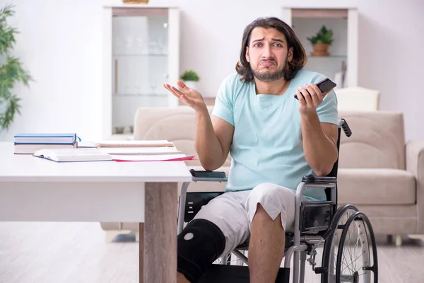 Joven estudiante en silla de ruedas estudiando en casa — Foto de Stock