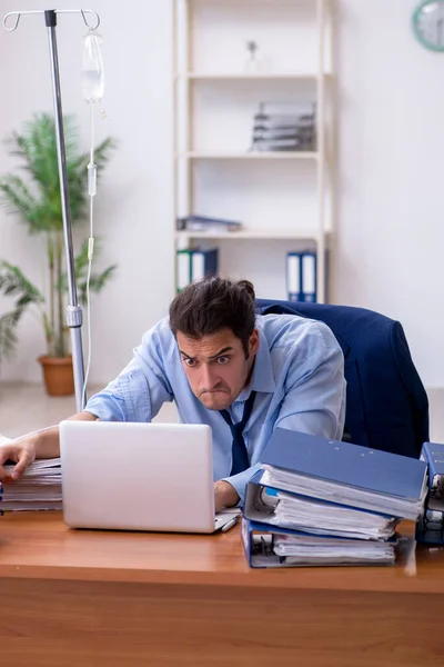 Ung manlig anställd som lider på arbetsplatsen — Stockfoto