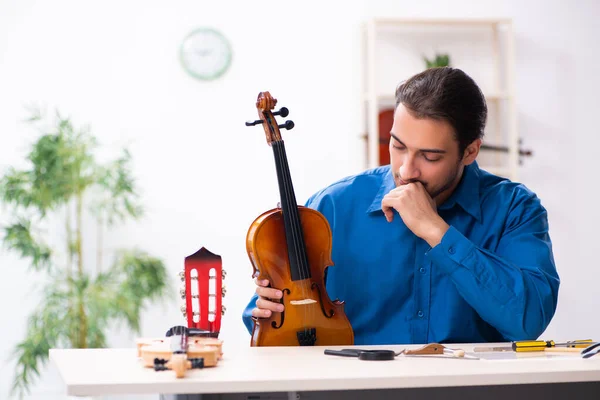 Jonge mannelijke reparateur die viool repareert — Stockfoto