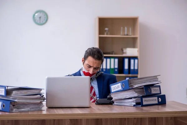 Empleado masculino encadenado descontento con el trabajo excesivo en la oficina — Foto de Stock