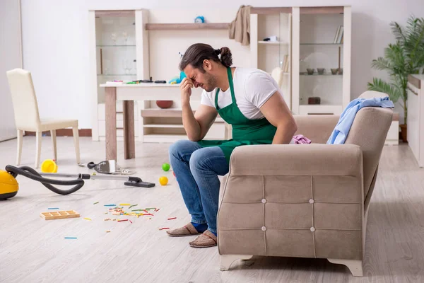 Młody mężczyzna wykonawca sprzątanie mieszkanie po dzieci strony — Zdjęcie stockowe