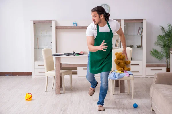 Jovem empreiteiro masculino limpando o apartamento após a festa das crianças — Fotografia de Stock