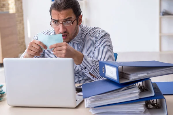 Молодий чоловік букмекер обчислює податкові платежі в офісі — стокове фото