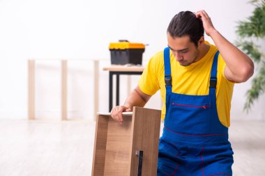 Genç erkek marangoz içeride çalışıyor.