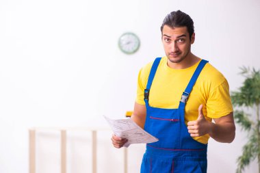 Genç erkek marangoz içeride çalışıyor.