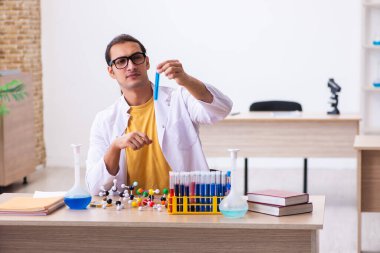 Sınıftaki genç erkek kimyacı öğretmen.