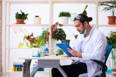 Laboratuvarda çalışan genç erkek kimyager parfümcüsü.