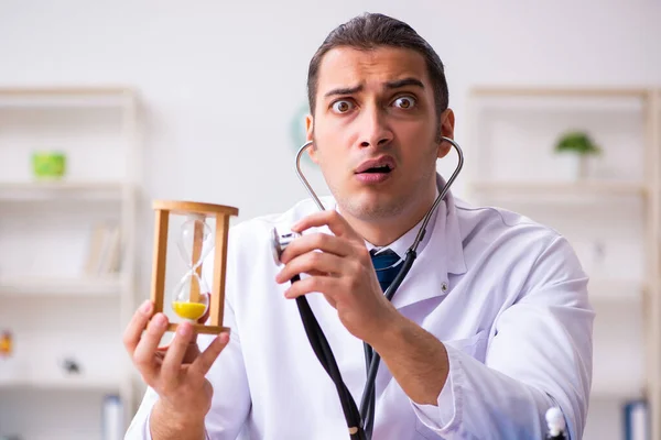 Young male doctor in time management concept — Stock Photo, Image