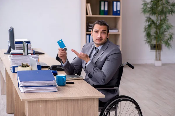 Giovane dipendente di sesso maschile in sedia a rotelle sul posto di lavoro — Foto Stock