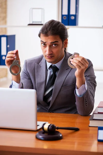 Young male lawyer sitting in the office