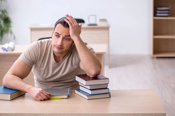 Joven estudiante masculino preparándose para los exámenes en la biblioteca — Foto de Stock