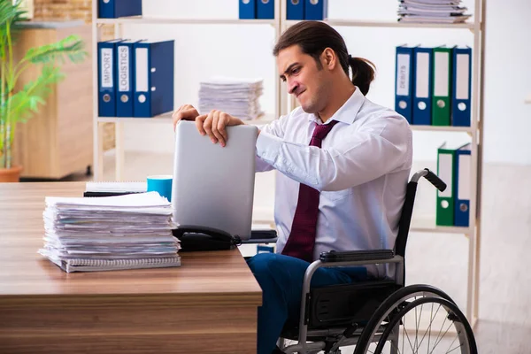 Joven empleado masculino después de accidente en silla de ruedas en el lugar de trabajo — Foto de Stock