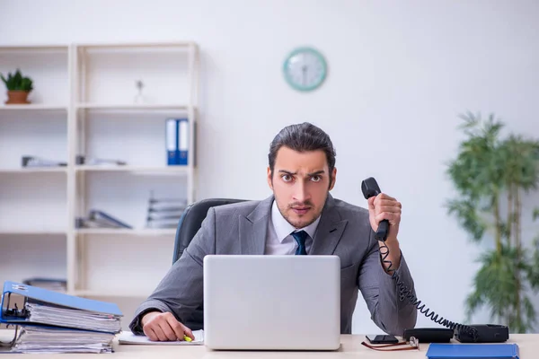 Junge männliche Angestellte unzufrieden mit exzessiver Arbeit im Büro — Stockfoto