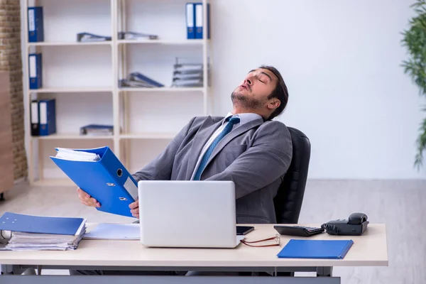 Jovem funcionário masculino infeliz com excesso de trabalho no escritório — Fotografia de Stock