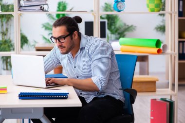 Ofiste çalışan genç bir erkek.