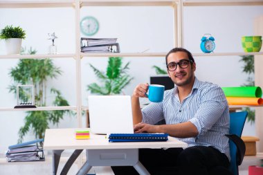 Ofiste çalışan genç bir erkek.