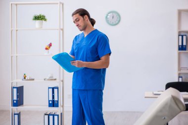 Genç erkek doktor hastanede not alıyor.