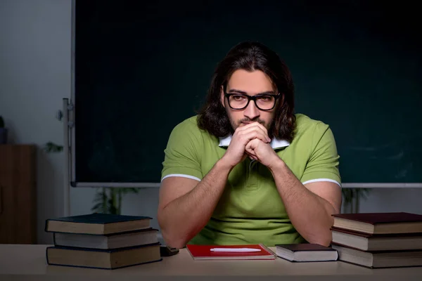 Jonge mannelijke student bereidt zich voor op examens in de klas — Stockfoto