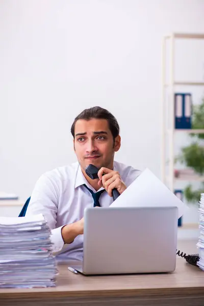 Giovane dipendente maschio infelice con il lavoro eccessivo — Foto Stock