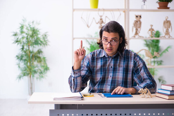 Молодой преподаватель-палеонтолог в классе
