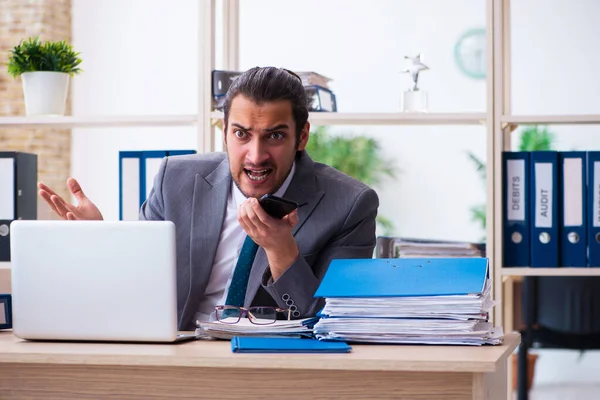 Giovane dipendente maschio e troppo lavoro in ufficio — Foto Stock