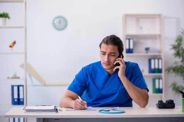 Jonge mannelijke arts in telegeneeskunde concept — Stockfoto