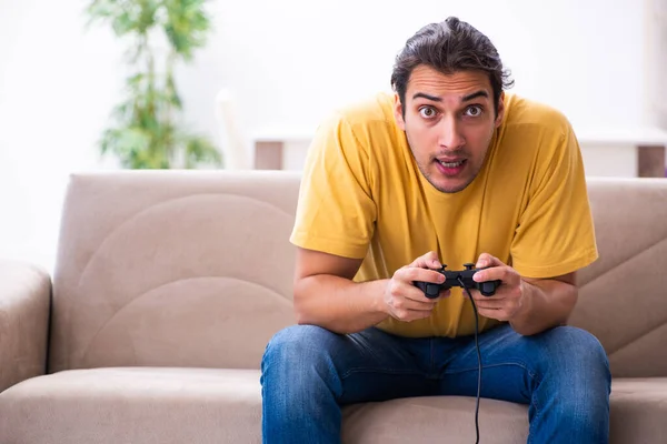 Ung man spelar joystick spel hemma — Stockfoto
