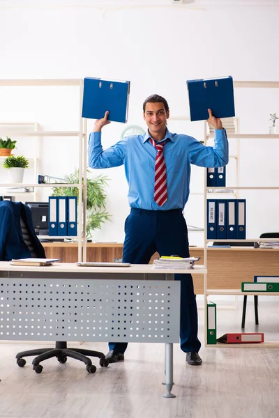 Giovane dipendente maschio che fa esercizi sportivi sul posto di lavoro — Foto Stock