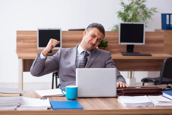 Giovane dipendente maschio infelice con il lavoro eccessivo — Foto Stock