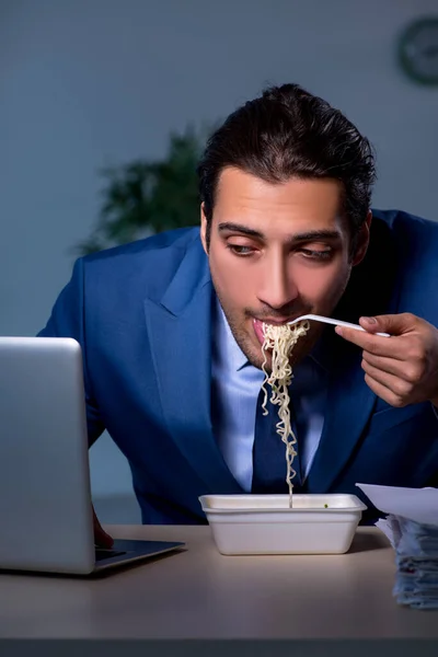 Hungriger Mitarbeiter arbeitet spät im Büro — Stockfoto