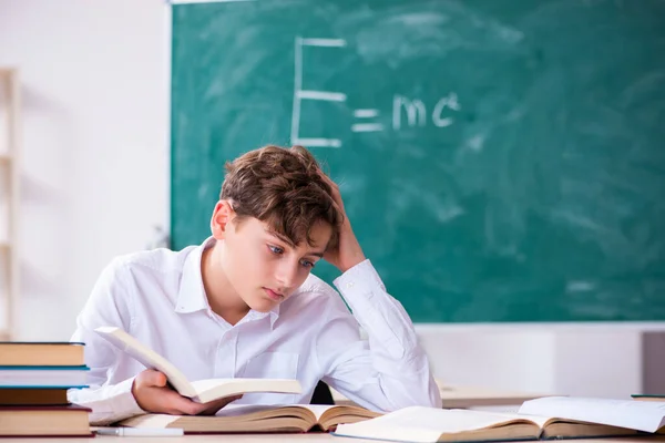 Schooljongen natuurkundige voor het groene bord — Stockfoto