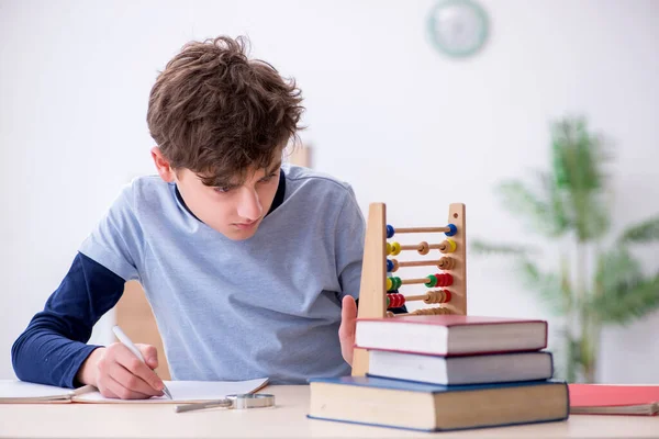 Colegial con ábaco estudiando matemáticas en casa — Foto de Stock