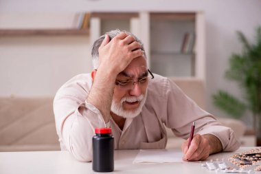 Yaşlı hasta adam evde acı çekiyor.