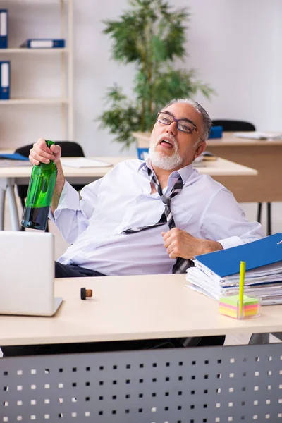 Un vieil employé boit de l'alcool au bureau — Photo