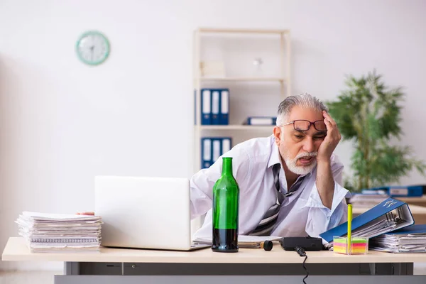 Stary pracownik pije alkohol w biurze. — Zdjęcie stockowe