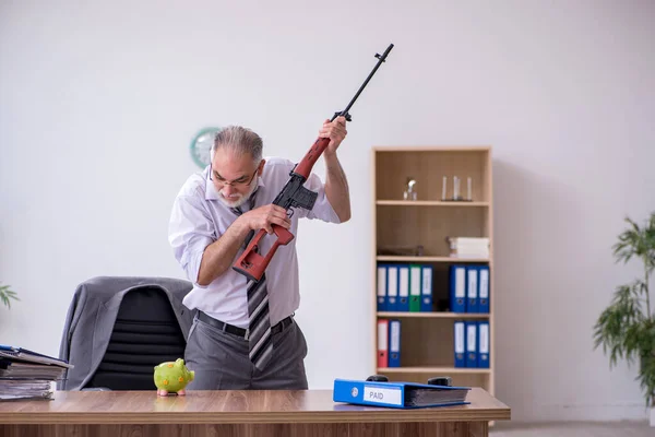 Alter männlicher Mitarbeiter hält Gewehr in Budgetplanungskonzept — Stockfoto