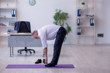 Mola sırasında fiziksel egzersiz yapan yaşlı bir erkek.