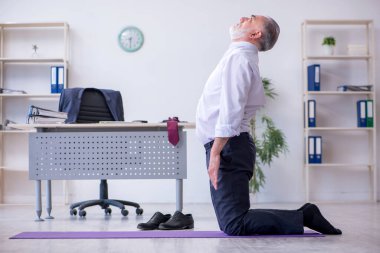 Mola sırasında fiziksel egzersiz yapan yaşlı bir erkek.