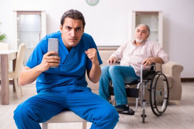 Tekerlekli sandalyedeki yaşlı adam ve genç kötü bakıcı.
