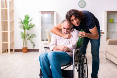 Tekerlekli sandalyedeki yaşlı adam ve genç kötü bakıcı.