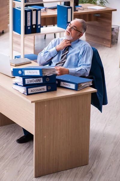 Старий чоловік бухгалтер незадоволений надмірною роботою на робочому місці — стокове фото